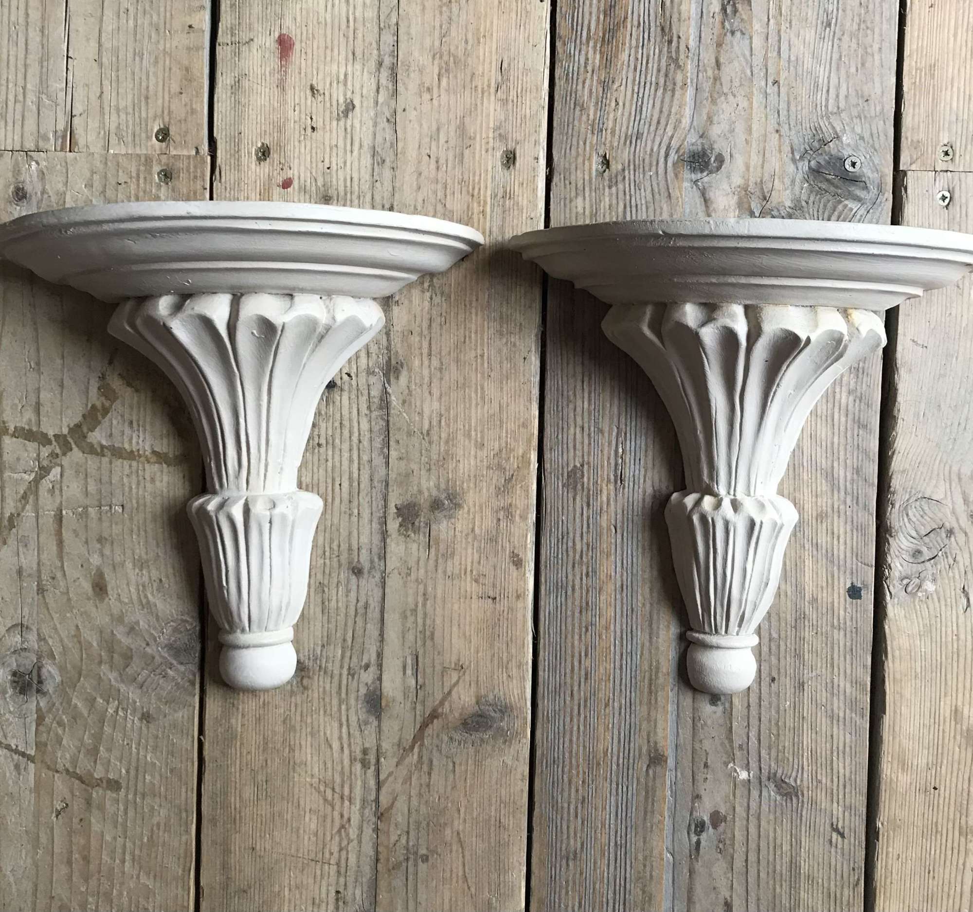 A pair of carved wooden & painted wall bracket shelves