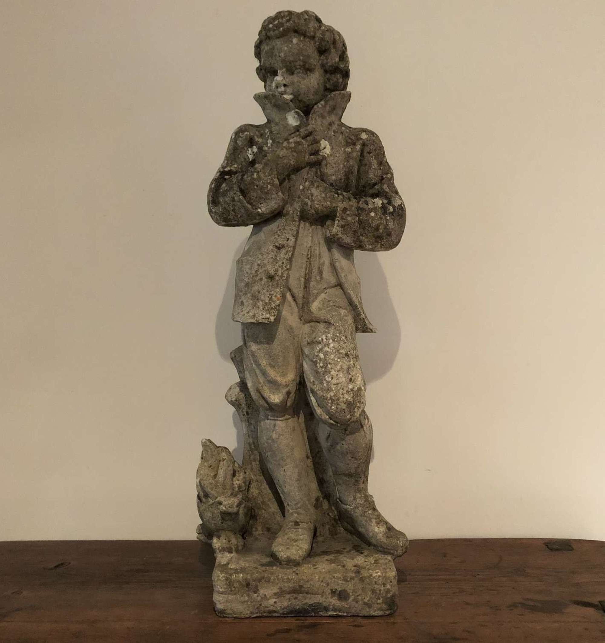 A cast stone statue of a boy