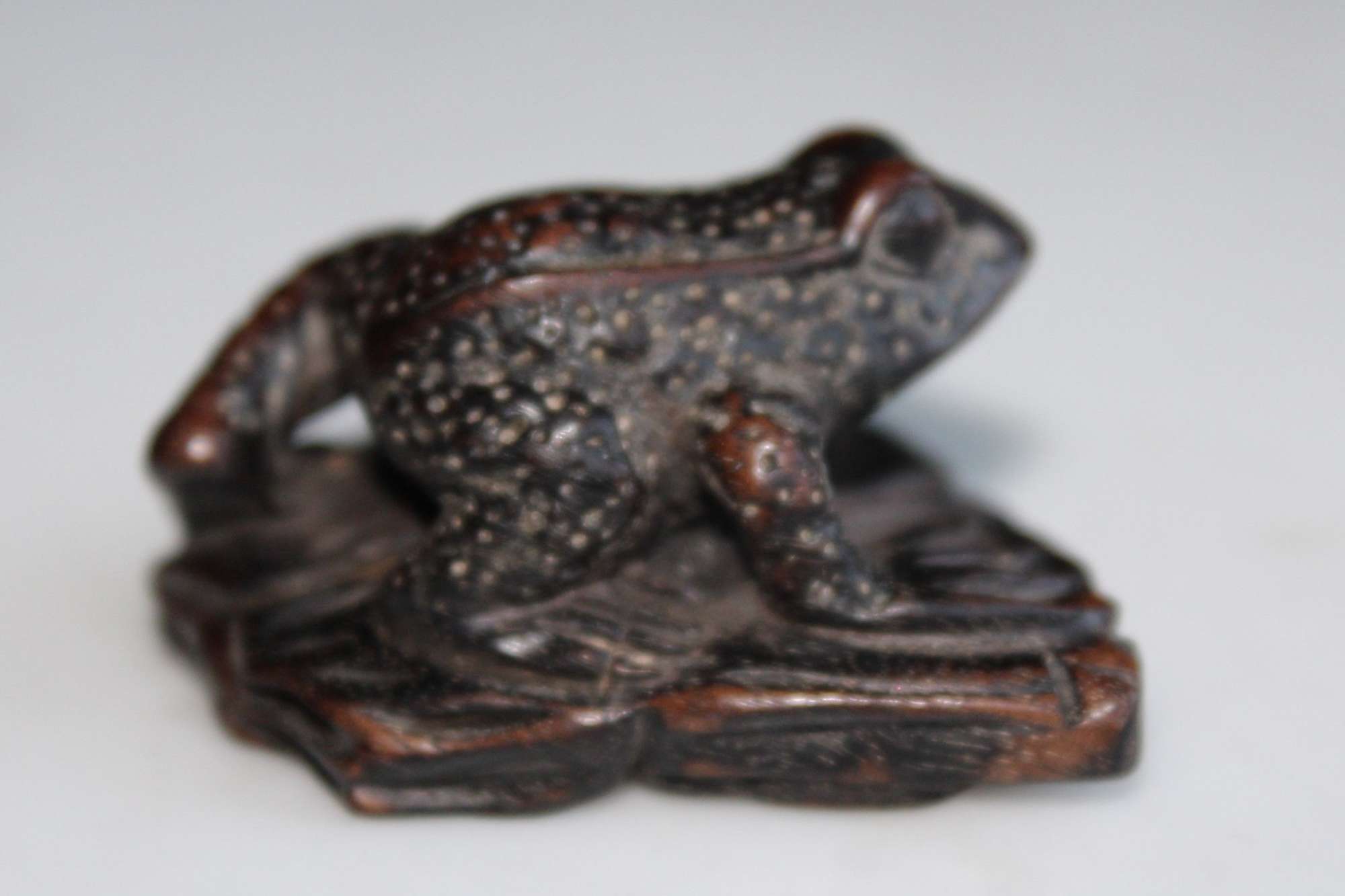 A finely carved small wood netsuke of a frog