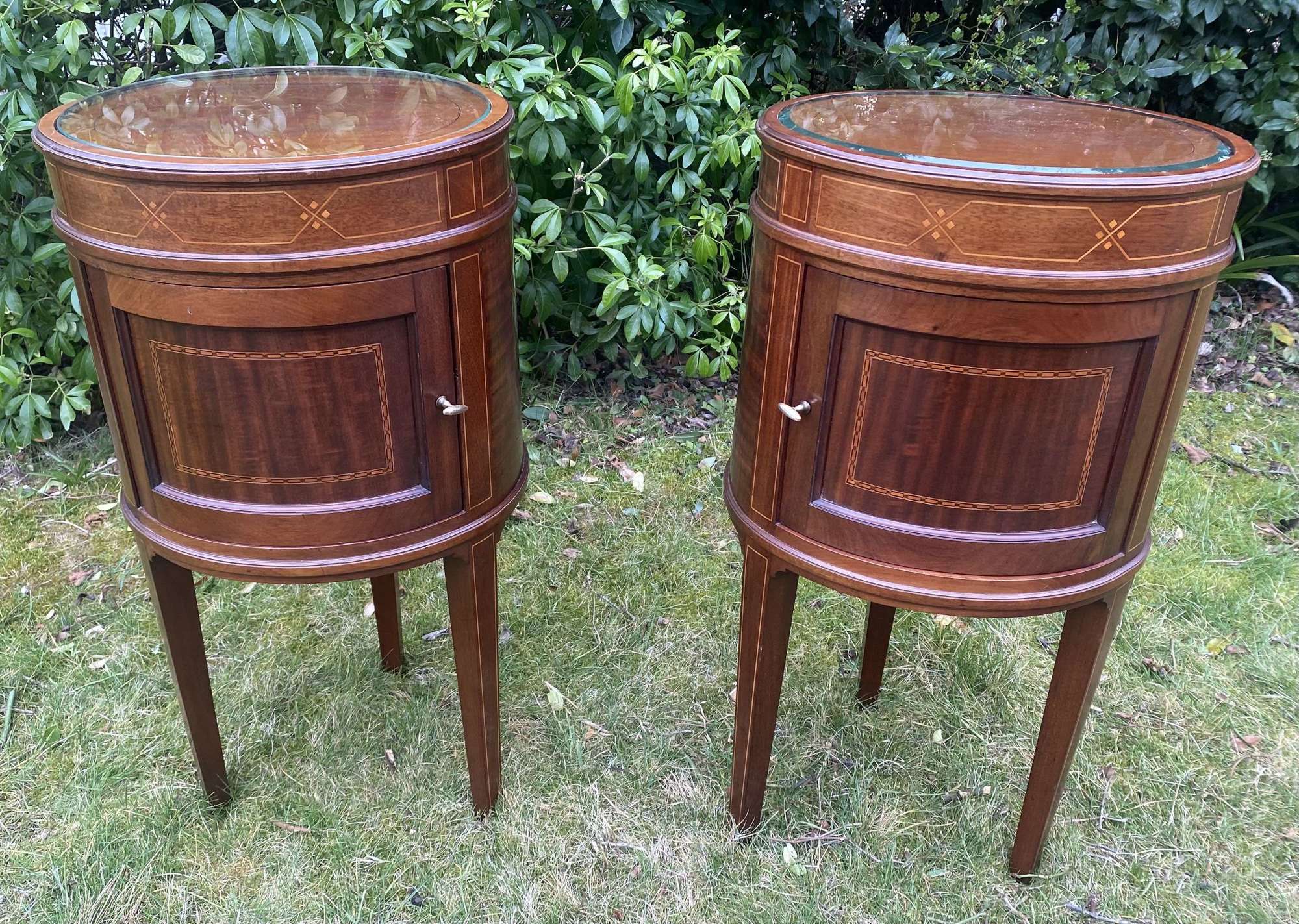 Pair of oval mahogany bedside tables