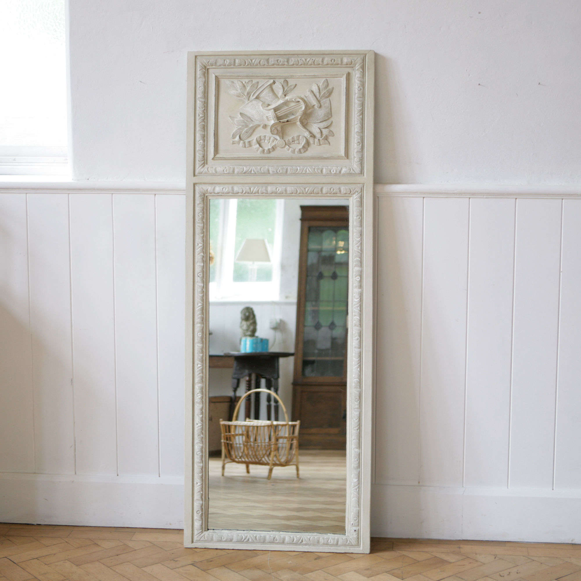 Painted oak trumeau mirror with carved musical detail