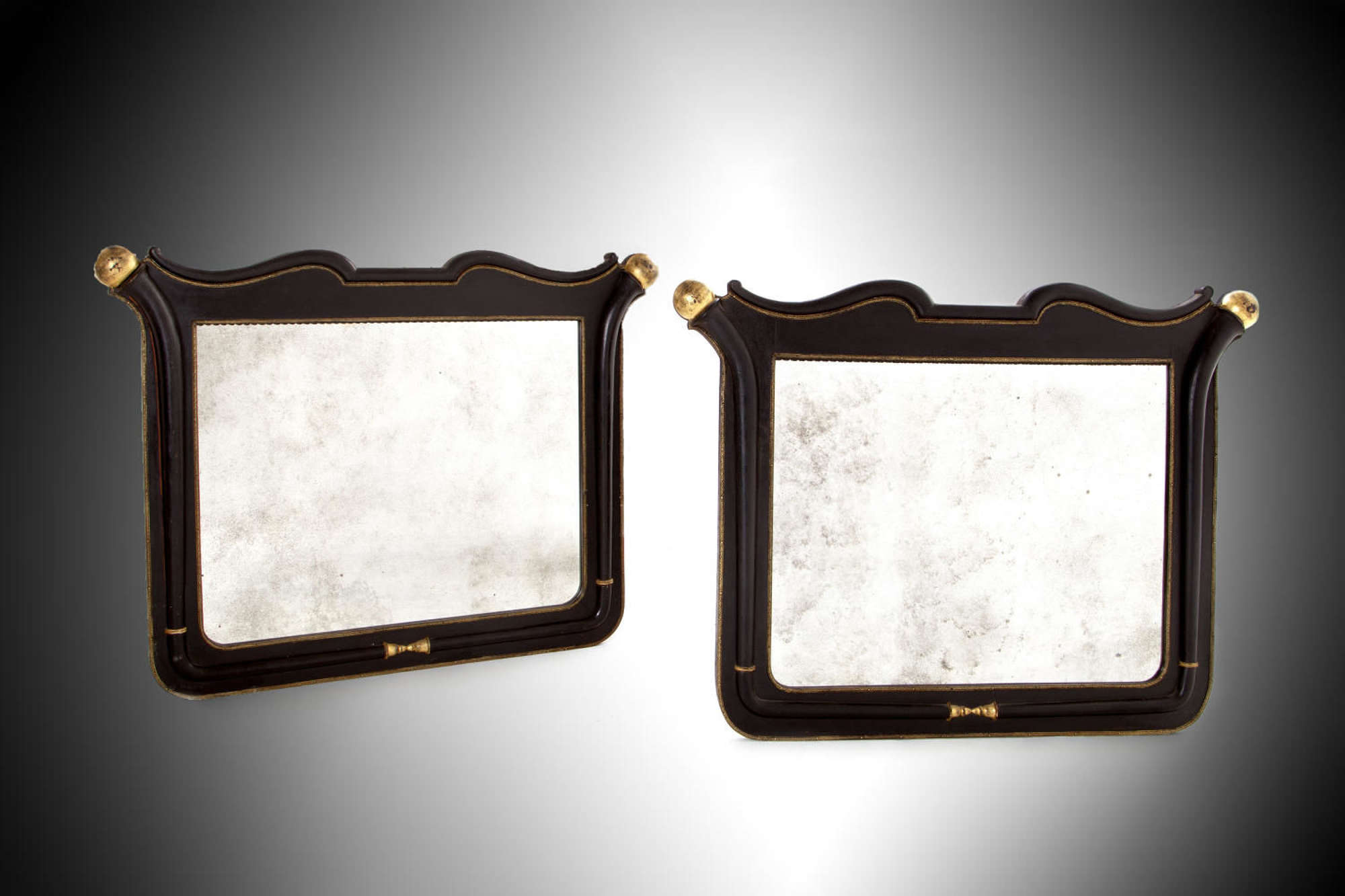 A pair of 19th century black and gold overmantel mirrors