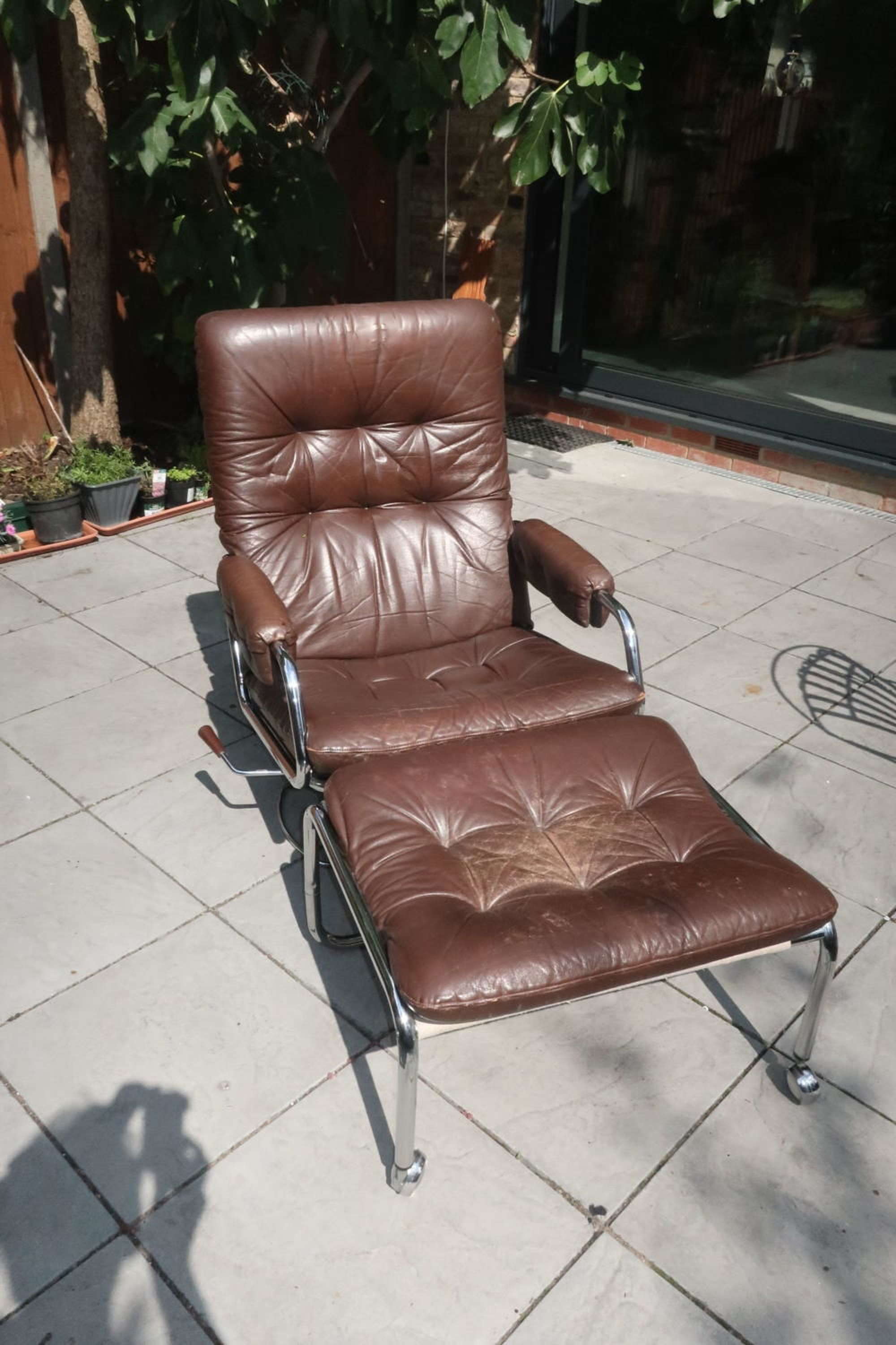 70’s chromed steel and brown leather armchair and stool