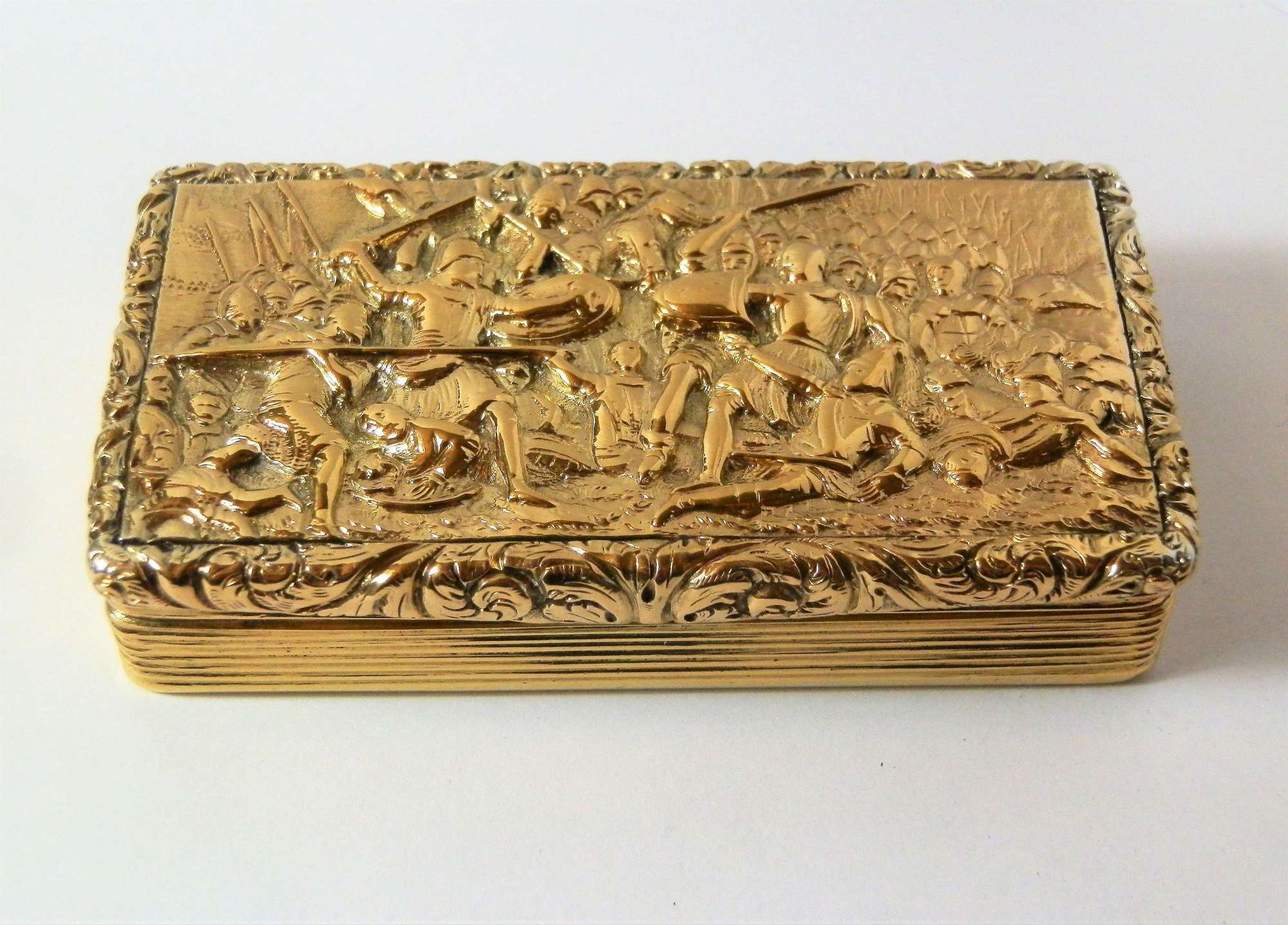 A George IV silver gilt battle scene snuff box, Birmingham 1827