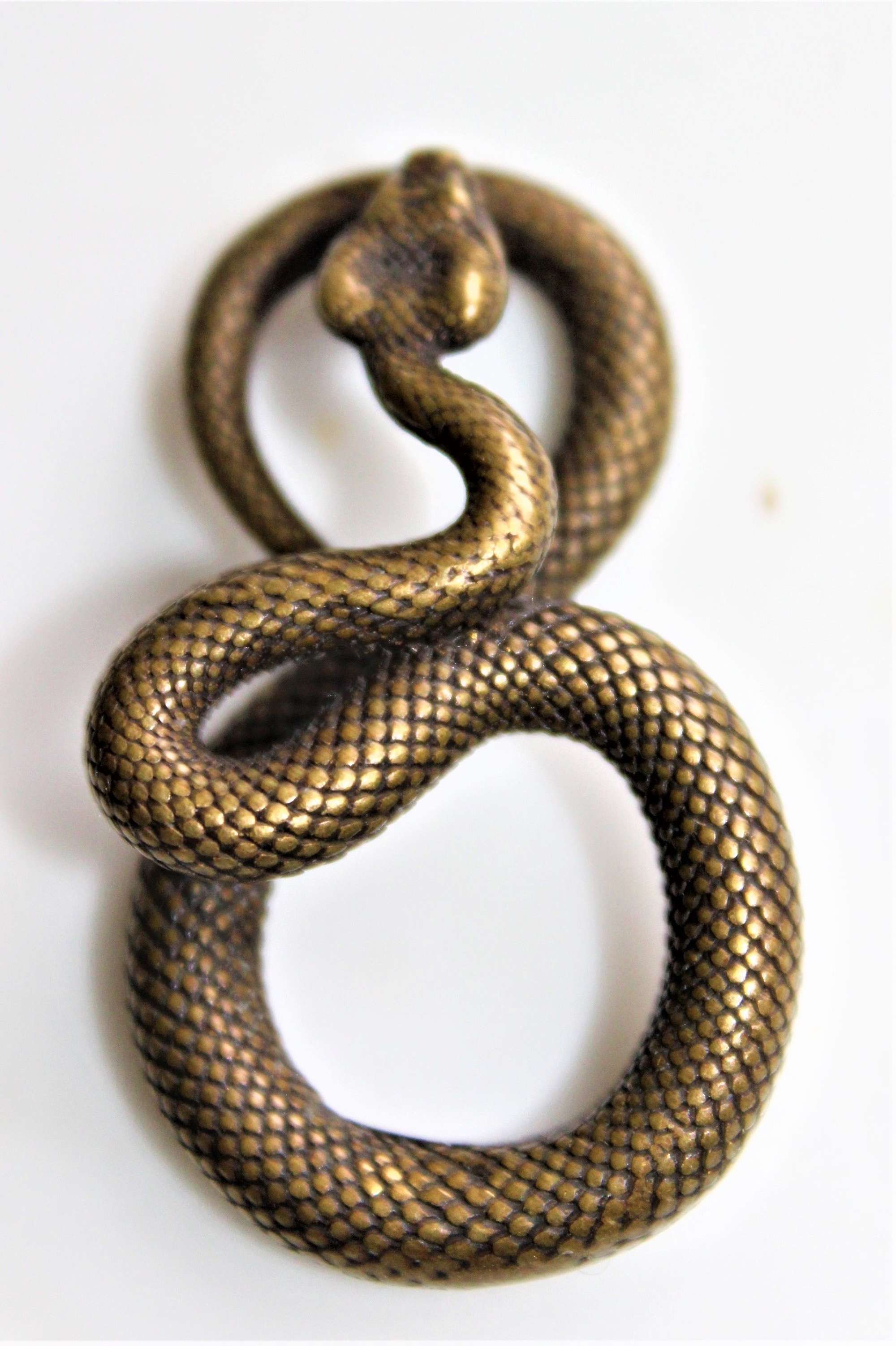 A Small Well Defined Bronze Pendant Of A Coiled Snake