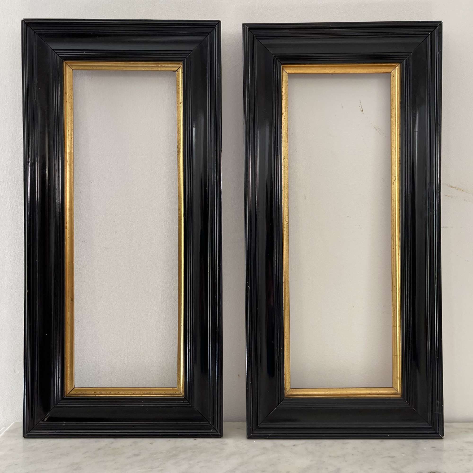 Pair of black lacquered pier mirrors with gilt slips